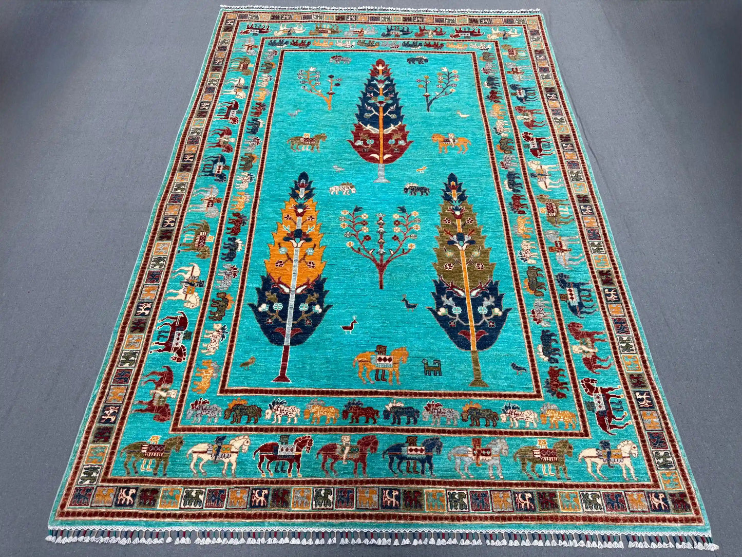 Full view of Tree of Life wool rug in turquoise blue on floor