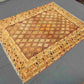 Floor display of beige, gold, and brown handwoven tribal rug in living room