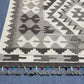Close-up corner with tribal diamond design on monochrome Kilim rug