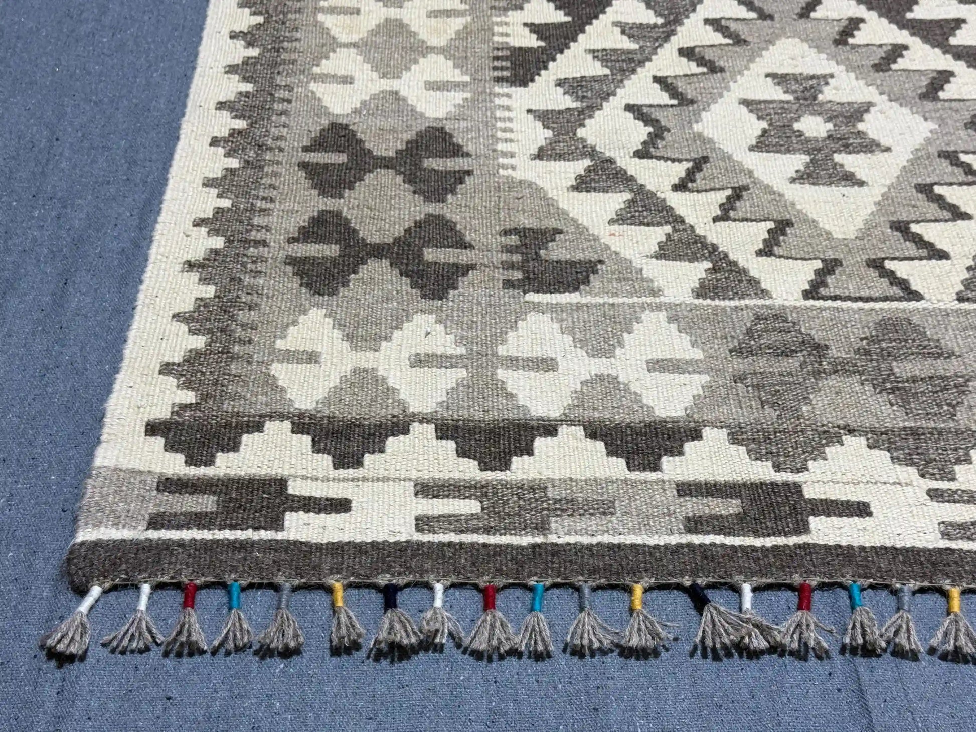 Close-up corner with tribal diamond design on monochrome Kilim rug