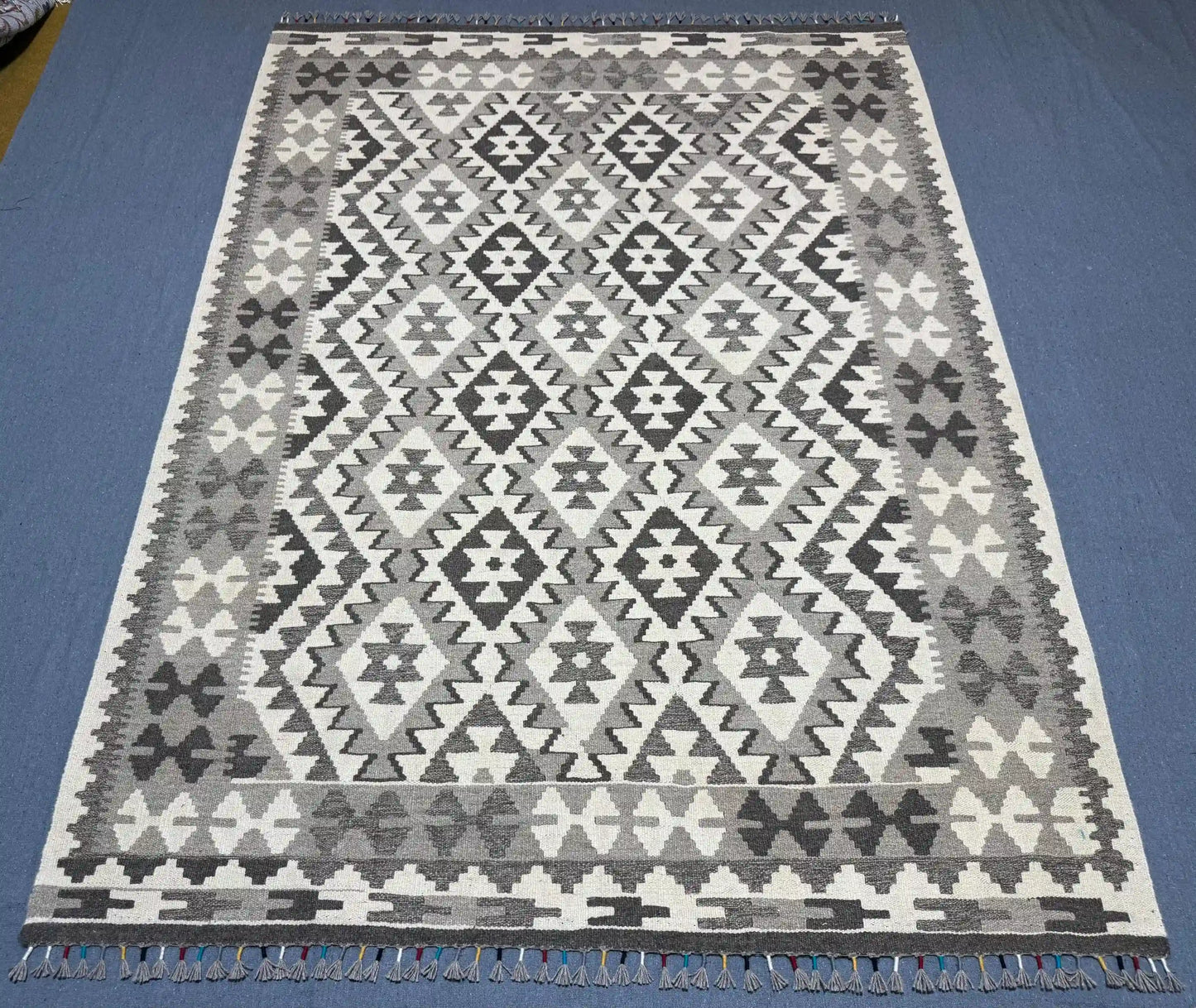 Floor view of tribal patterned wool Kilim rug in monochrome colors