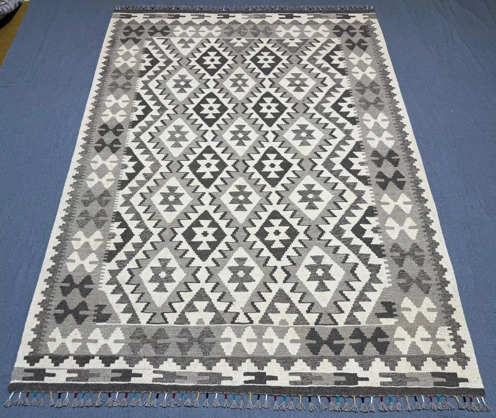 Floor view of tribal patterned wool Kilim rug in monochrome colors