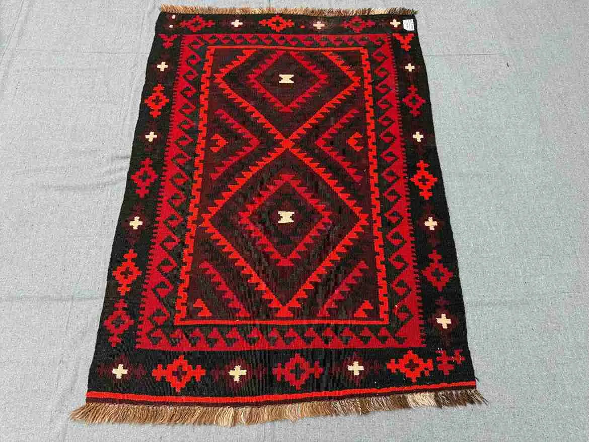 Tribal pattern 5x8 Kilim rug on wooden floor – vintage handmade Turkish wool flatweave.