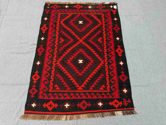 Tribal pattern 5x8 Kilim rug on wooden floor – vintage handmade Turkish wool flatweave.