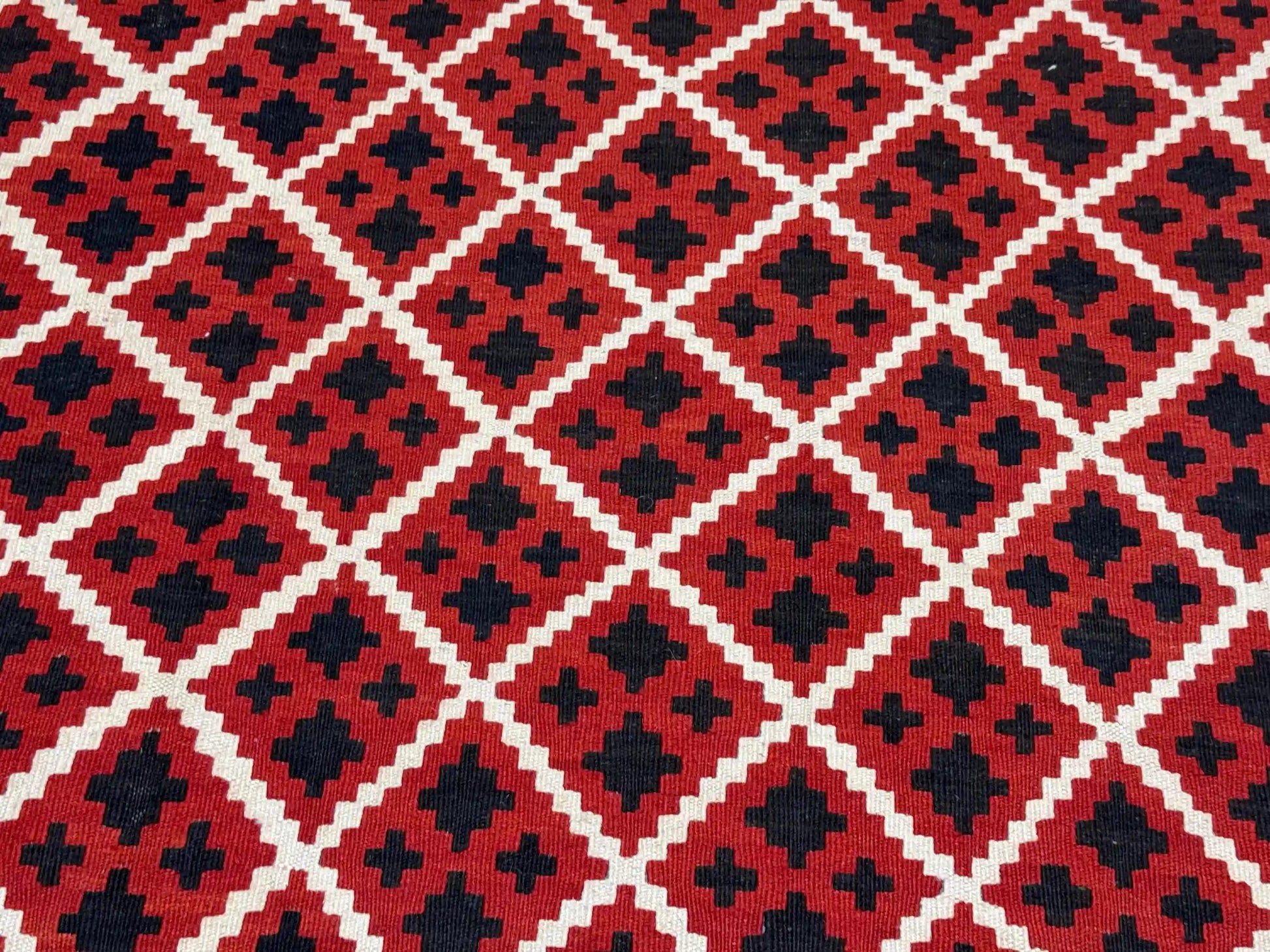 Detailed pattern from corner of boho tribal kilim rug – red wool