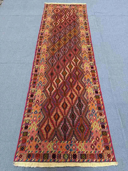 Long view of geometric kilim runner on floor showing its length