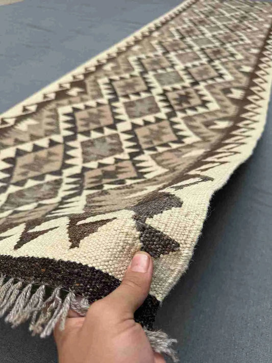 Turkish Boho Kilim runner rug held to show handmade wool texture