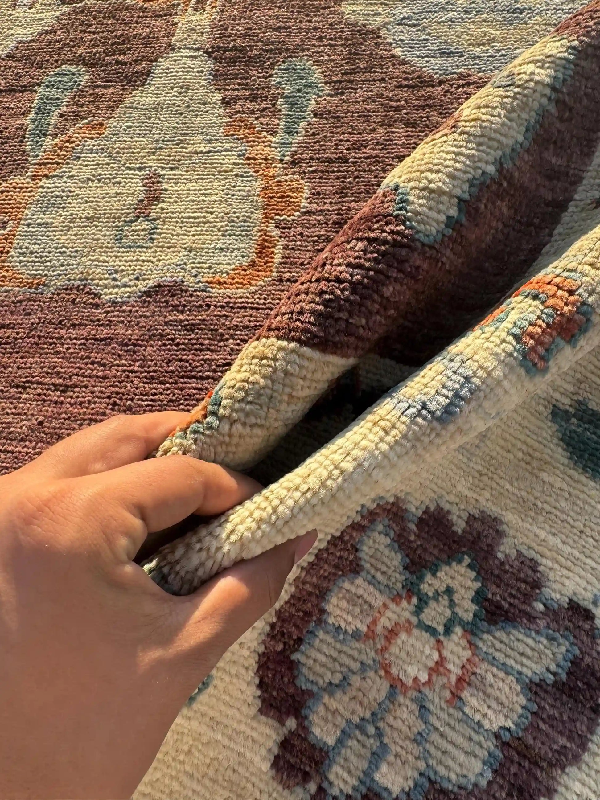 Handmade Turkish Oushak Rug 5x7 ft shown in hands – hand-knotted beige and brown wool carpet