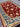 Back view of Turkish red wool rug held to highlight authentic hand-knotting