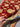 Handmade Turkish red rug held in hands showing front floral wool pattern