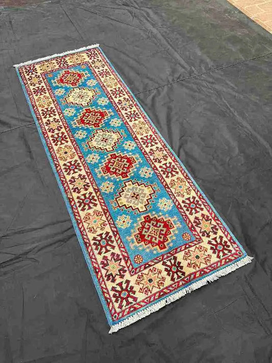 Handmade Turkish Kazakh runner rug displayed on wood floor