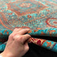 Hand-knotted vibrant Mamluk rug held in hand with rich wool silk texture