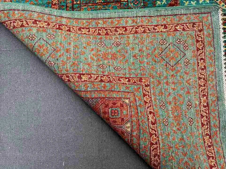 Folded vibrant Mamluk carpet showing fine wool weave and rich tones