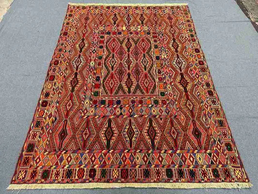 Vintage tribal kilim rug on wooden floor in living room setup