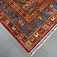 Corner view of vintage Pazyryk rug on wooden floor