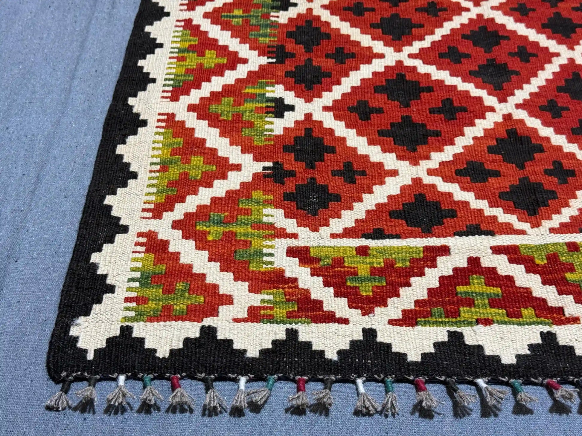 Corner detail of 5x7 handmade red kilim rug – vintage geometric design