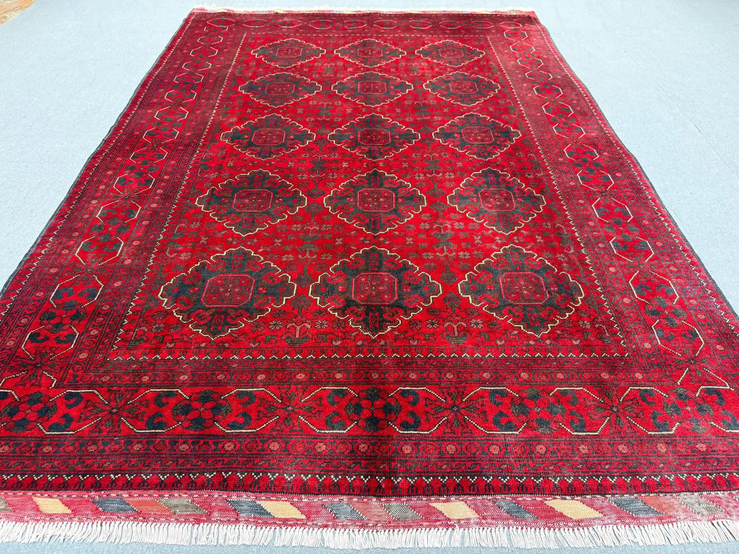Handmade red wool tribal rug styled in a bedroom