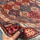 5x7 handmade Waziri rug in hand showing wool texture and tribal detail
