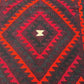Close-up texture of wool flatweave – vintage Turkish Kilim rug with knotted tribal patterns.