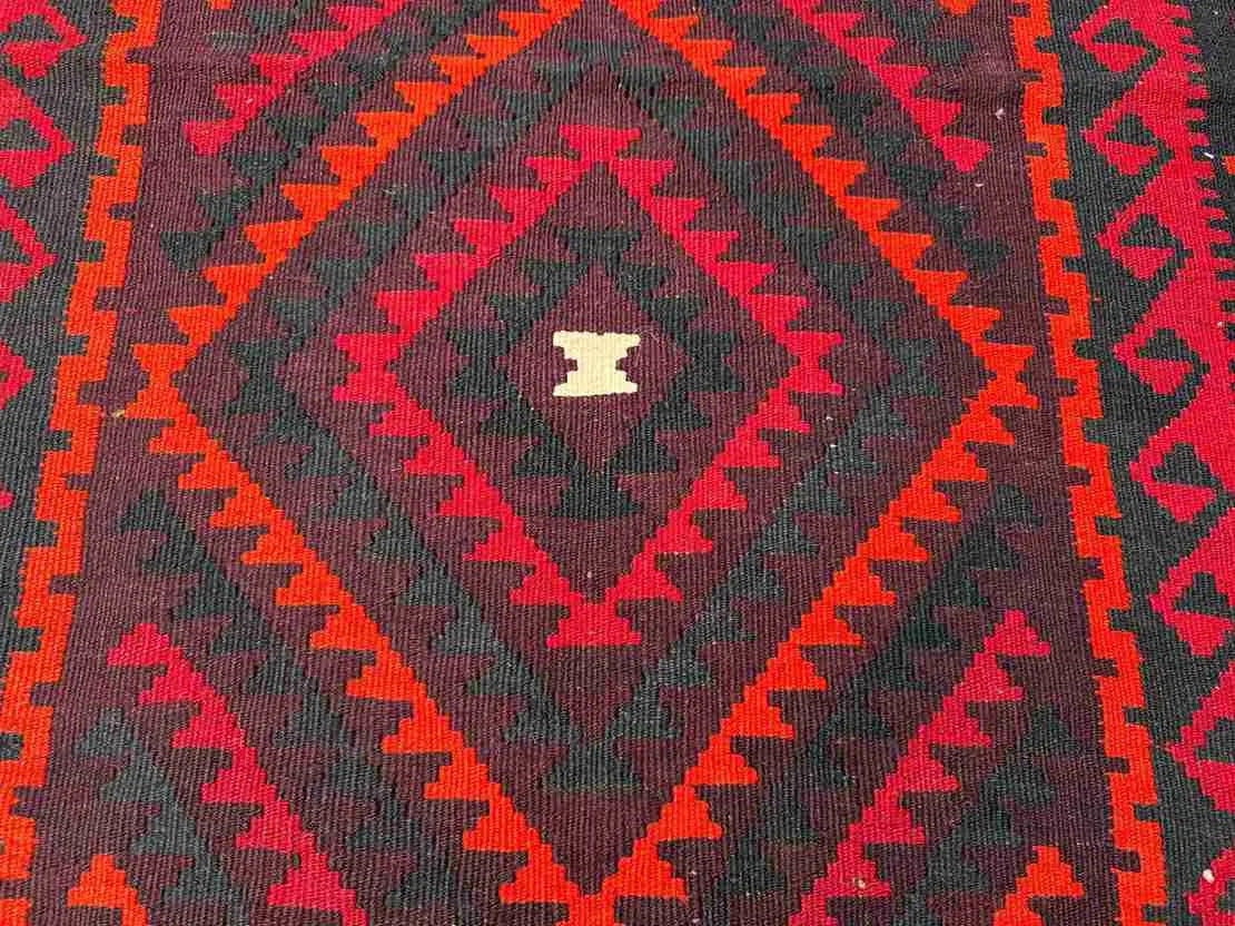 Close-up texture of wool flatweave – vintage Turkish Kilim rug with knotted tribal patterns.