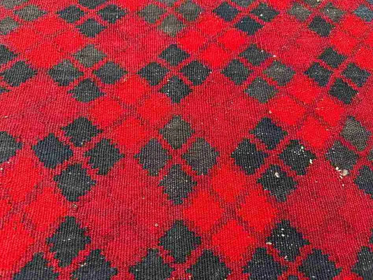 Close-up texture of wool flatweave on small red Afghan Kilim – authentic handwoven finish.