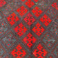Close-up of wool flatweave – handmade Kilim rug in small size with red and earthy tones.