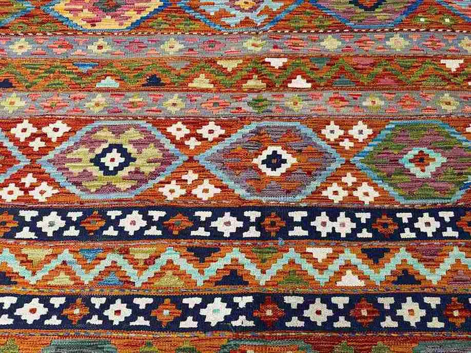 Close-up of wool flatweave texture – vibrant handmade 8x11 Persian-style Khorjin rug.
