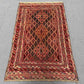 Layout of vintage Persian Afghan rug styled in a home setting