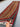 Handwoven wool shawl held in hands – red, black, blue, gold tribal stripe