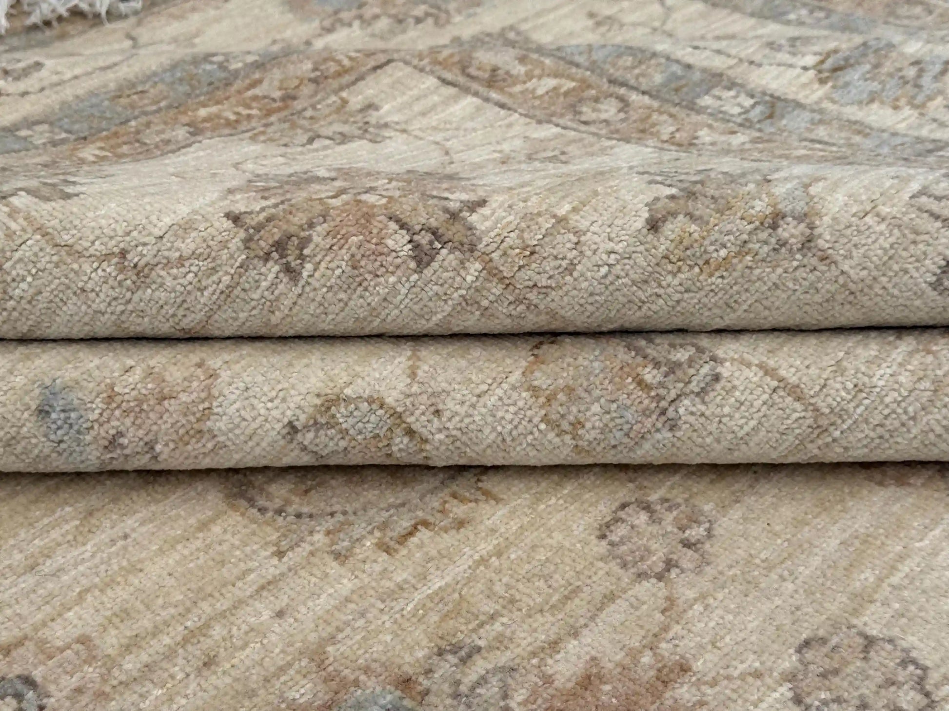 Folded handmade wool Ziegler carpet showing weave detail